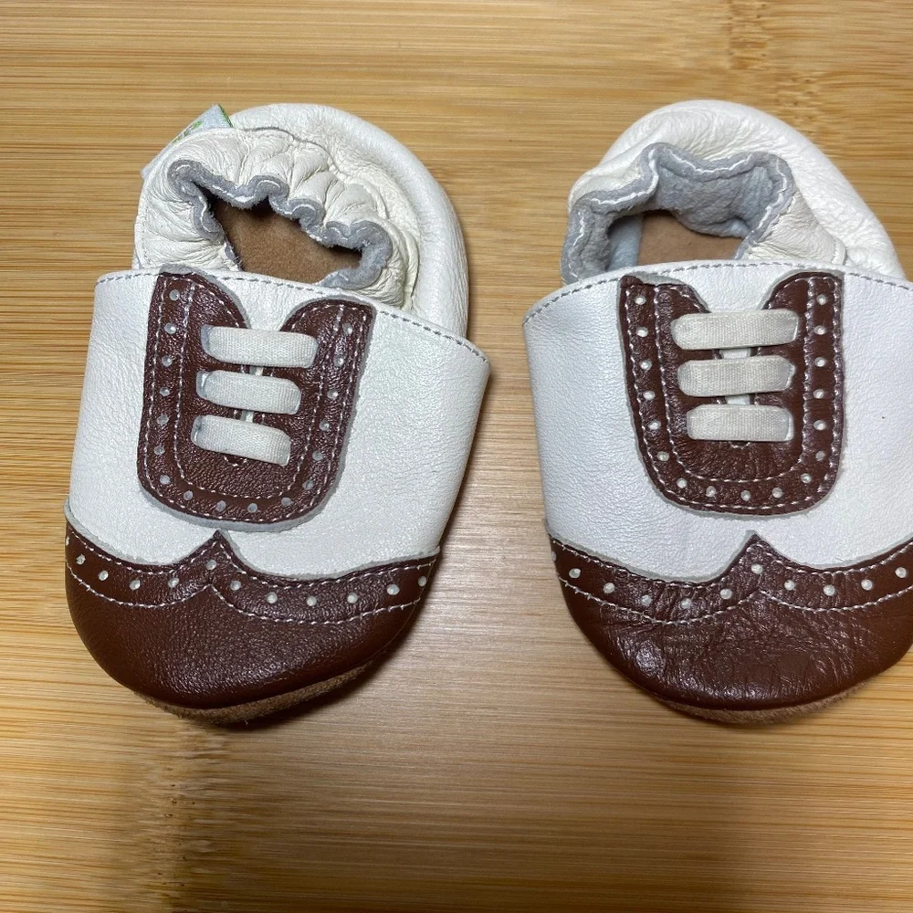 White and brown wingtip baby shoes